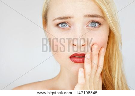Shocked and amazed red-haired woman portrait. Attractive carroty girl touching her cheek in shock of information, free space