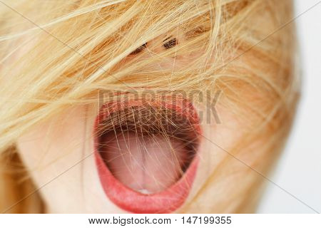 Unrecognizable woman with open mouth and covered face with red hair. Exclaiming carroty girl close-up portrait. Delight, enthusiasm, fun concept