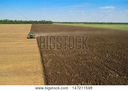 KRASNODAR REGION, RUSSIA - AUG 19, 2015: Modern tractor plows big field, In 2015 in Krasnodar region yields reached record level - 58.4 centners per hectare