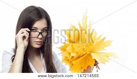 closeup portrait of attractive  caucasian smiling woman brunette isolated on white studio shot lips toothy smile face hairlooking at camera tooth hand holding yellow marple autumn leaves
