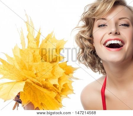 closeup portrait of attractive  caucasian smiling woman blond isolated on white studio shot lips toothy smile face hair  looking at camera blue eyes tooth hand holding yellow marple autumn leaves