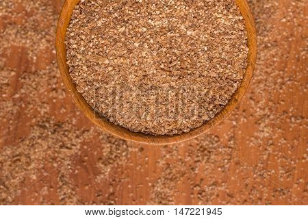 Ground Wheat into a bowl over a wooden table. Trigo para quibe. Kibbeh