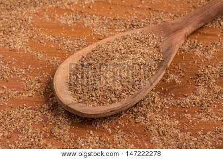 Ground Wheat into a spoon over a wooden table. Trigo para quibe. Kibbeh