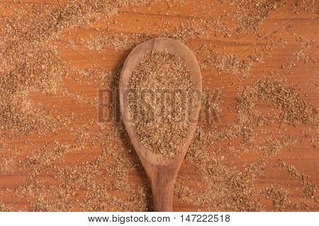 Ground Wheat into a spoon over a wooden table. Trigo para quibe. Kibbeh