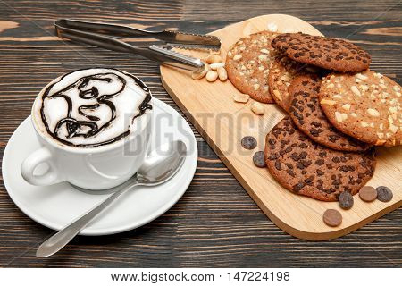 Oatmeal cookies with nuts and chocolate. Hot coffee with air foam