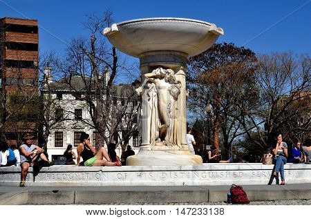 Washington DC- April 12 2014: People relaxing in front of Daniel Chester French's marble fountain in the center of Dupont Circle on a warm Spring afternoon