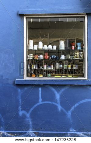 Window with shelves with assorted bric a brac set in a blue wall