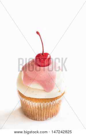 Vanilla cup cake with cherry on white background selective focus