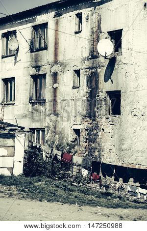 Old residential houses with laundry clothes drying on sun in poor area on town street