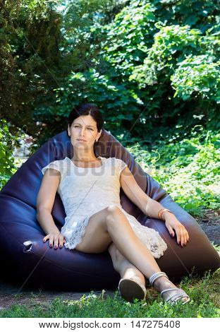 Young beautiful brunette woman enjoying sitting and resting in the woods