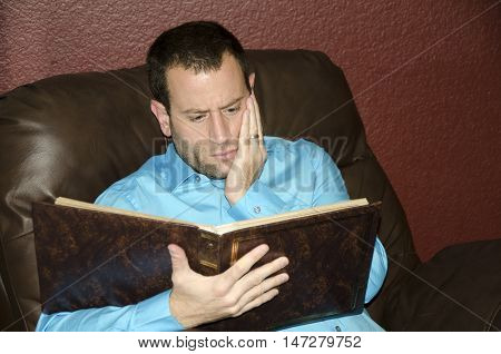 Man reminiscing looking at an old photo album.