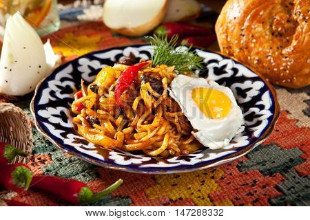 Asian Style Noodles with Meat and Laghman Sauce. Garnished with Fried Egg