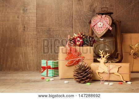 Christmas gift boxes and rustic ornamnets on wooden table