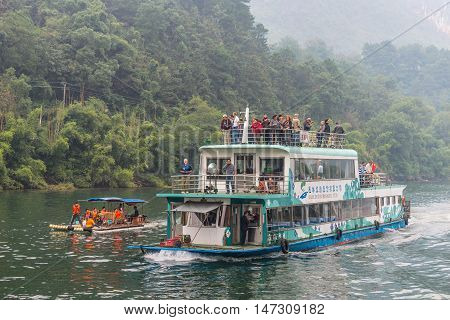 Yangshou China - October 20 2013: A tourist boat packed with tourists travels the magnificent scenic route along the Li river from Guilin to Yangshou.