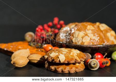 Typical Dutch filled spicy cookies with almonds on autumn colored and dark background