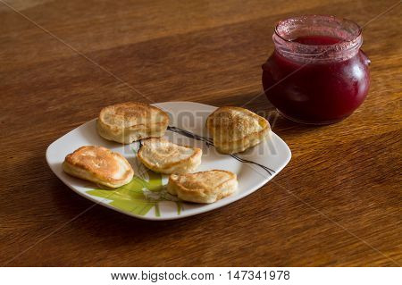 Olady (traditional ukrainian pancakes) with jar of strawberry jam.