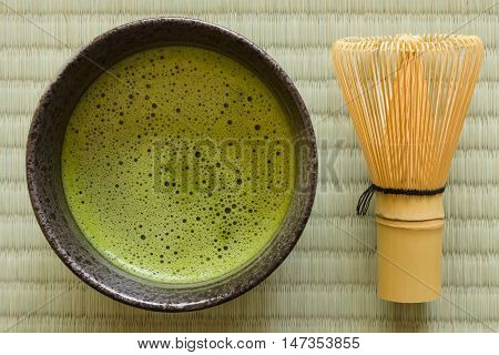 Japanese Matcha green tea in a chawan or traditional ceramic bowl with a chasen or bamboo whisk