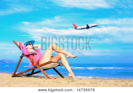 Młoda kobieta sexy relaks na plaży z samolotu, przechodząc za nią - koncepcja podróży