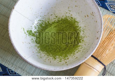 Japanese Matcha green tea powder in a chawan or traditional ceramic bowl with a chasen or bamboo whisk