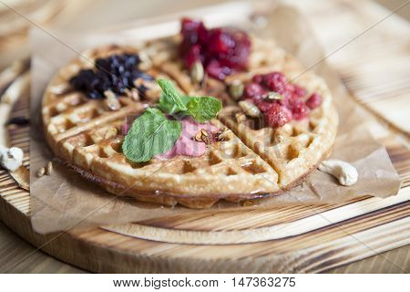 Plate of belgian waffles with ice cream, caramel sauce and fresh berries