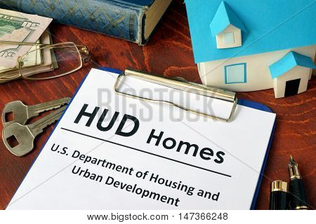 Paper with words HUD homes on a wooden surface.