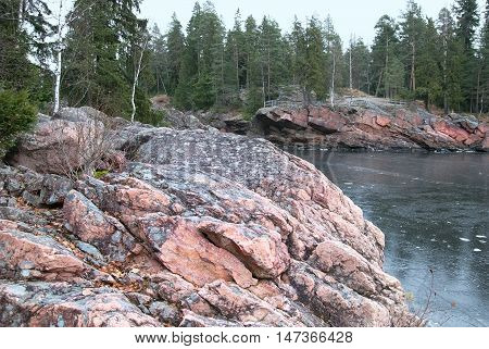 Imatra. Finland. Granite boulders on The Vuoksi River next to The Imatrankoski Rapids. On the background is The Kruununpuisto Park