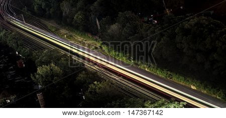 Red rails as passing subway train melts into light streak.  
Long exposure on a subway train passing by on its night runs in Toronto City, Canada.  Red glow emanates from passing taillights.