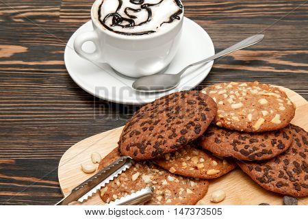 Oatmeal cookies with nuts and chocolate. Hot coffee with air foam