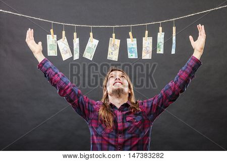 Riches and fortune. Young happy man with a lot of money on black background. Winning the lottery concept.