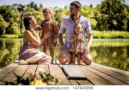 Young Family On Pier Near Lake
