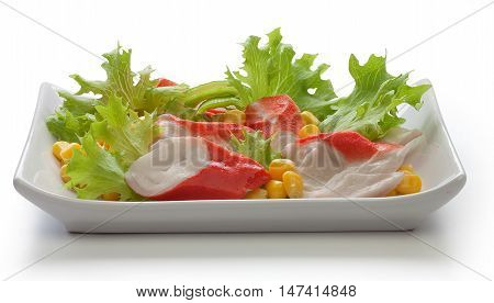 Crab meat with fresh green lettuce and corn's seeds on the plate