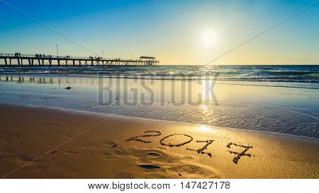 New Year 2017 number sign drawn on sand at the beach.
