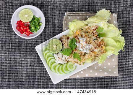 Fried rice with crab topped streamed crab,halve green lemon,sliced cucumber,lettuce and coriander  served  spicy  sour filling side dish.  Top view