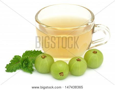 Herbal tea in a cup with amla and mint leaves