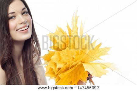 closeup portrait of attractive  caucasian smiling woman brunette isolated on white studio shot lips toothy smile face hair  looking at camera tooth hand holding yellow marple autumn leaves