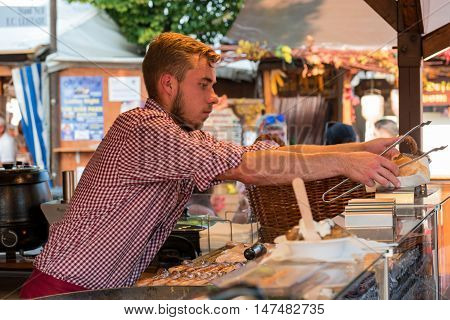 10th September 2016, Bad Dürkheim, Wurstmarkt 2016 (wine festival), Germany: An undefinite male person on the sausage market working and serving fresh cooked food