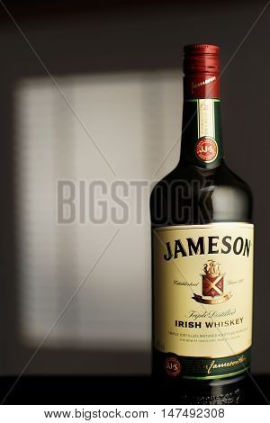 MINSK, BELARUS-AUGUST 25, 2016. Jameson is a blended Irish whiskey produced by the Irish Distillers subsidiary of Pernod Ricard. A bottle Jameson in the room illuminated by the light from the window