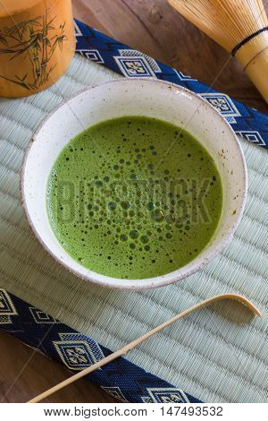 Japanese Matcha green tea in a chawan or traditional ceramic bowl with a tatami mat background