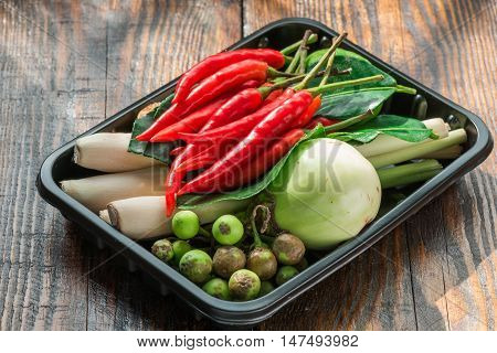 Tom kha ingredients set for Thai cooking in black plactic pallet on wooden table