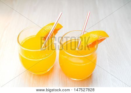 Very healthy orange cocktail with straw into glass for breakfast