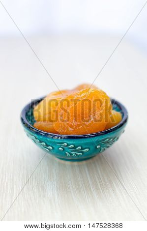 Orange dried apricots on a blue plate