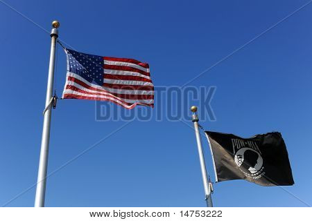 Spojené státy americké vlajky letí vedle černé vlajky POW/MIA nad modrá obloha