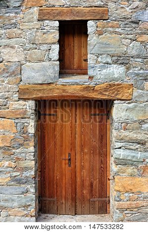 mountain alpien architecture wooden door on the facade of rocks masonry