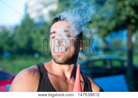 Man Exhaling Smoke Inhaling From A Hookah