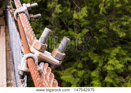 Two bolts connected to metall rope on suspention bridge