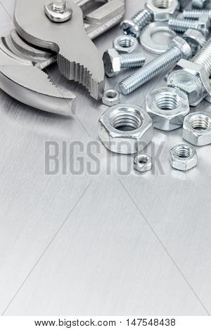 Tools For Construction Including Slip-joint, Screws And Bolts On Scratched Metal Surface