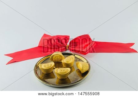 Gold ingot on golden plates white background