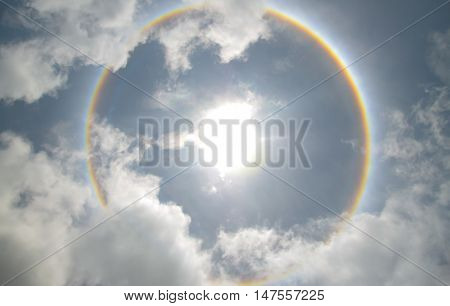 Sun with circular rainbow sun halo occurring due to ice crystals in atmosphere in thai