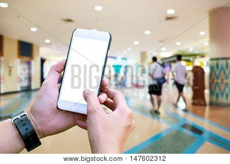 Human using Mobile Phone with blank screen on Department store blurred background