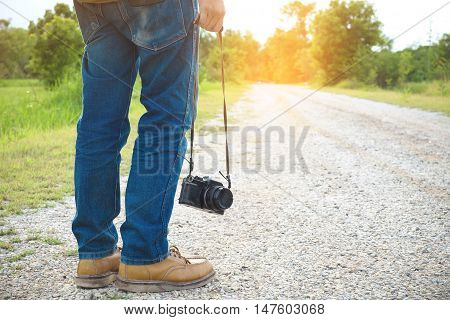 Feet Traveler man and retro photo camera outdoor Travel Lifestyle vacations and travel concept vintage tone